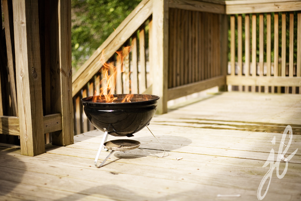 charcoal grill flames on small patio deck